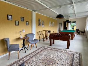 a living room with a pool table and chairs at Pousada Princesa Isabel - Visconde in Petrópolis