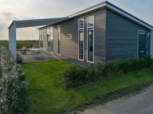 a small house with a patio and a table at Holiday Home Ruisweg 45 by Interhome in Wemeldinge