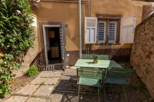 a green table and chairs in front of a building at Appartement Cosy avec Jardin au Centre Historique de Sélestat & Proche Europa-Park in Sélestat