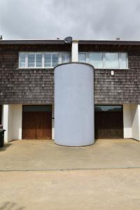 a brick building with a cylindrical object in front of it at Les Dunes in Camber