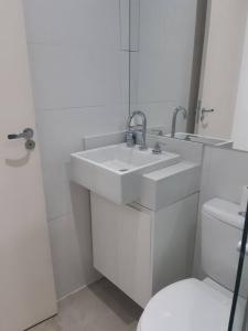 聖保羅的住宿－Varanda_77，白色的浴室设有水槽和卫生间。