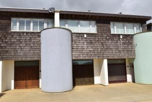 a house with three garage doors and two at Les Dunes in Camber