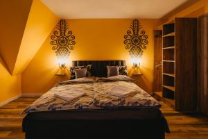 a bedroom with a large bed with yellow walls at Dunajecko Dziupla in Biały Dunajec