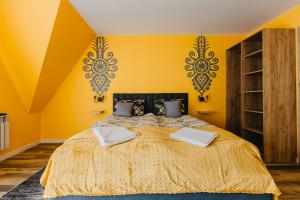 ein Schlafzimmer mit gelben Wänden und einem großen Bett in der Unterkunft Dunajecko Dziupla in Biały Dunajec