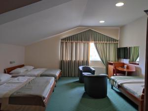 a hotel room with three beds and a desk at Hotel Bacchus in Livno