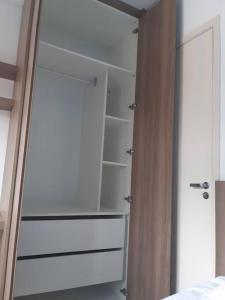 a closet with white shelves in a bedroom at Varanda_77 in Sao Paulo