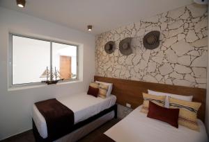 1 dormitorio con 2 camas y ventana en Lago en el Cielo Villas Boutique en Tolú