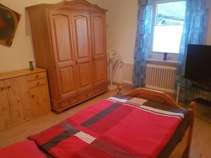una camera da letto con un letto, un armadio e una finestra di Entspannen & Wohlfühlen in der Lüneburger Heide a Vierhöfen
