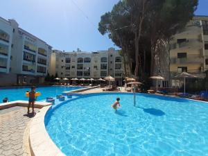 two people in a swimming pool at a hotel at Kingu's Apartment in Golem