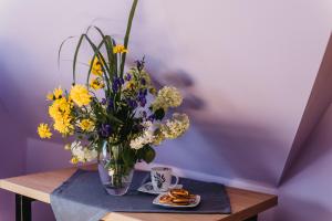 wazon wypełniony kwiatami na stole w obiekcie Dunajecko Dziupla w Białym Dunajcu