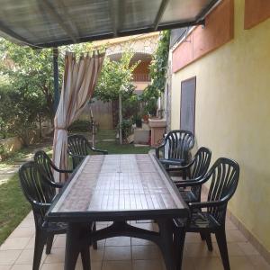 drewniany stół i krzesła na patio w obiekcie Appartamento Le Ginestre w mieście Monte Nai