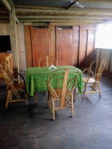 a table with chairs and a green table cloth on it at Golden waters Lodges in Iquitos
