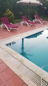 a swimming pool with two chairs and an umbrella at Relaxation Villa with private pool in Alexandria