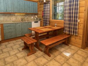 une cuisine avec une table et des bancs en bois dans l'établissement Holiday Home Kinostupa 2a - 18 by Interhome, à Ruka