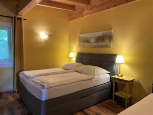 - une chambre dotée d'un lit avec un mur jaune dans l'établissement Holiday Home Schweiger by Interhome, à Maurach