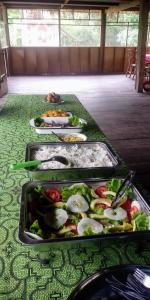 una mesa con varias bandejas de comida. en Golden waters Lodges, en Iquitos