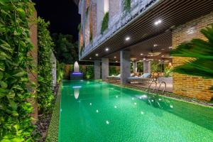 a swimming pool in the middle of a yard at night at Boutik Cham NhaTrang Hotel in Nha Trang