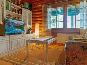een woonkamer met een tafel en een televisie bij Holiday Home Kalliorinne by Interhome in Pyhäjärvi