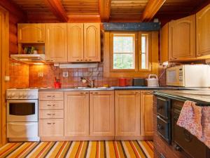 een keuken met houten kasten en een wastafel bij Holiday Home Kalliorinne by Interhome in Pyhäjärvi