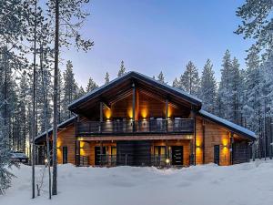 a log cabin in the woods in the snow at Holiday Home Tievachalets 6 b by Interhome in Sirkka