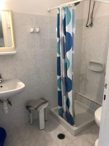 een badkamer met een douche met een blauw en wit douchegordijn bij Eleftheria Studios and Apartments in Acharavi