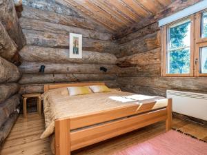 una camera con un letto in una baita di tronchi di Holiday Home Rantaruka 2c3 by Interhome a Ruka