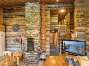 un soggiorno con camino in pietra in una baita di tronchi di Holiday Home Rantaruka 2c3 by Interhome a Ruka Altre 15 foto