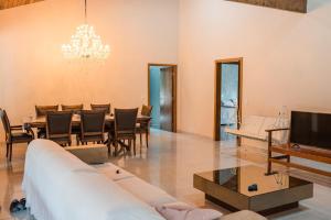 a living room with a dining table and a television at CASA DE CAMPO Banheira, Lareira e Cachoeira in Pedra Azul