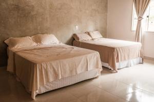 1 dormitorio con 2 camas y ventana en CASA LUXO-água quente-banheira-lareira-cachoeira. en Pedra Azul
