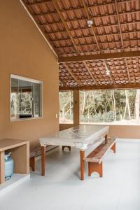 a ping pong table in a room with two benches at CASA DE CAMPO Banheira, Lareira e Cachoeira in Pedra Azul