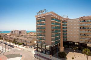 un grand bâtiment avec un panneau d'hôtel en haut dans l'établissement Hotel RH Vinaros Playa & Spa 4* Sup, à Vinaròs