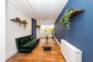 uma sala de estar com um sofá verde e uma parede azul em Morden 2 Bedroom flat Central Brighton Location Sleep 6 guests I G44CL em Brighton & Hove