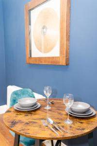 uma mesa de madeira com pratos e copos de vinho em Morden 2 Bedroom flat Central Brighton Location Sleep 6 guests I G44CL em Brighton & Hove