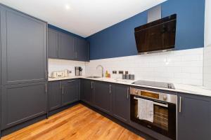 uma cozinha com armários pretos e uma parede azul em Morden 2 Bedroom flat Central Brighton Location Sleep 6 guests I G44CL em Brighton & Hove