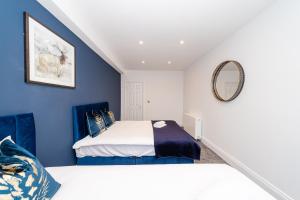 um quarto azul com uma cama e um espelho em Morden 2 Bedroom flat Central Brighton Location Sleep 6 guests I G44CL em Brighton & Hove