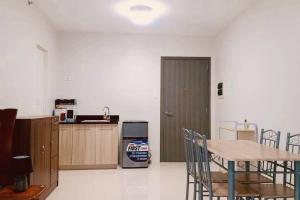 a room with a table and a kitchen with a refrigerator at Camella Homes Bacolod Condo - Ibiza Bldg Unit 5O for rent! with WIFI and Netflix! in Bacolod