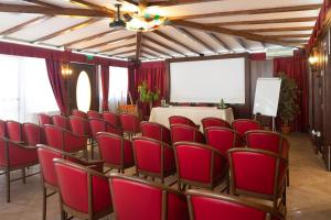 une salle de conférence avec des chaises rouges et une table blanche dans l'établissement Hotel Trinacria, à Palerme