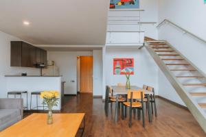 a kitchen and living room with a table and a staircase at Travelers Orange Suites in Medellín