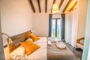 ein Schlafzimmer mit einem großen Bett mit orangefarbenen Kissen in der Unterkunft Behin Batean, espectacular casa rural en pleno corazón del valle Baztán in Ziga