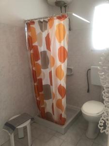 a bathroom with a toilet and a shower curtain at Eleftheria Studios and Apartments in Acharavi