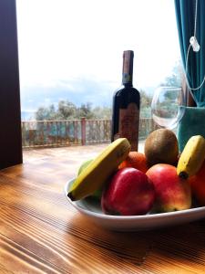 un plato de fruta en una mesa con una botella de vino en Kabak Armes Hotel en Faralya