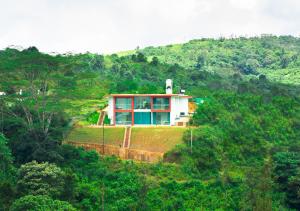 ein Haus auf einem Hügel mitten im Wald in der Unterkunft Hidden Valley Hill View Cottage Vagamon by VOYE HOMES in Vagamon