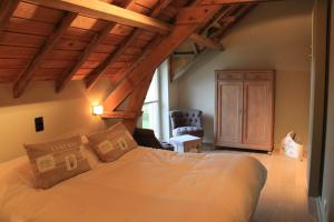 a bedroom with a bed in a room with wooden ceilings at B&B De Luyckhoek in Handzame