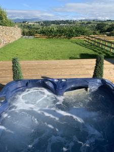 a jacuzzi tub with a view of a field at Luxury Cottage, views of the Lakes with Hot Tub in Cockermouth