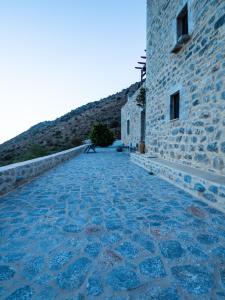 a stone walkway next to a building with a hill at Soloterra tower in Kokkala