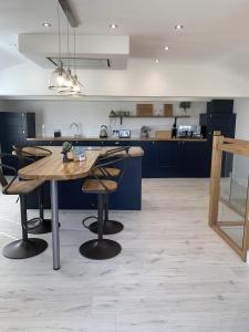 a large kitchen with a wooden table and chairs at Luxury Cottage, views of the Lakes with Hot Tub in Cockermouth