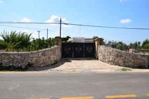 a gate to a house with a stone wall at Mamma Maria Salento - Alle Macchie in Marina di Pescoluse