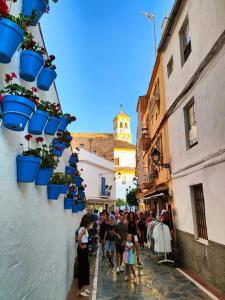 a group of people walking down a street with potted plants at Wallada Marbella in Marbella