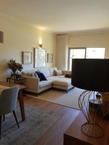 a living room with a couch and a table at JARDINS DA MARINA APARTMENT Ai in Albufeira