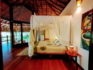 a bedroom with a bed with a canopy at Pousada Boutique Sitio das Jaqueiras-Vista Rio Mar in Santo André +130 photos
